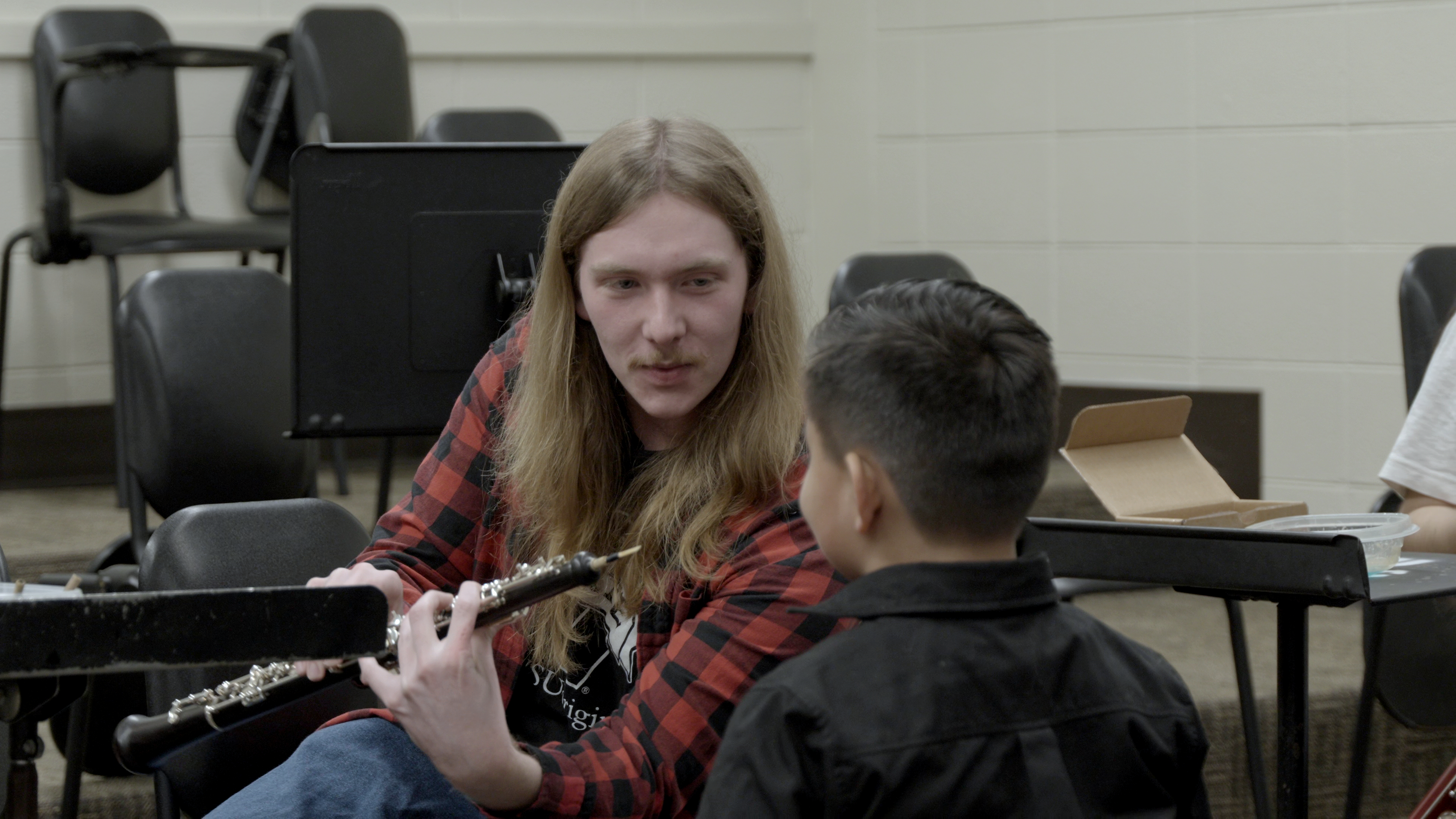 A child trying an instrument at the Tunes for Tots instrument petting zoo